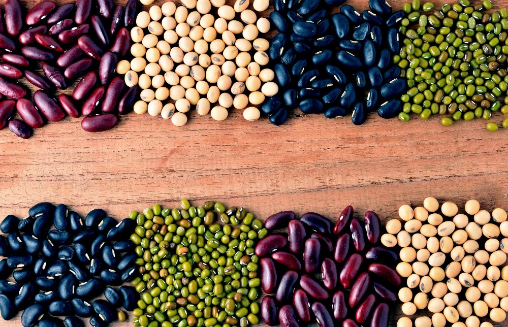 Dažādu krāsu pupiņas, sojas pupas un mung pupiņas uz koka virsmas