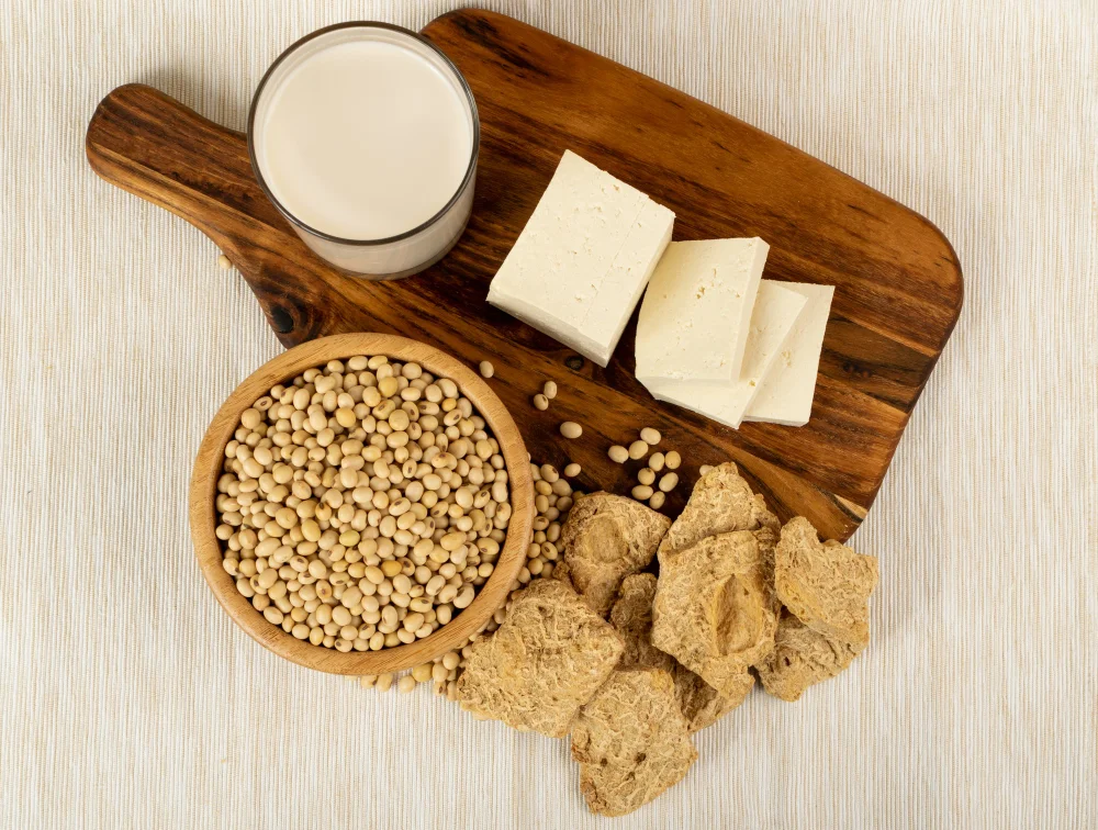 Sojas pupiņas, tofu siers, sojas piens un sojas gabaliņi uz koka dēlīša